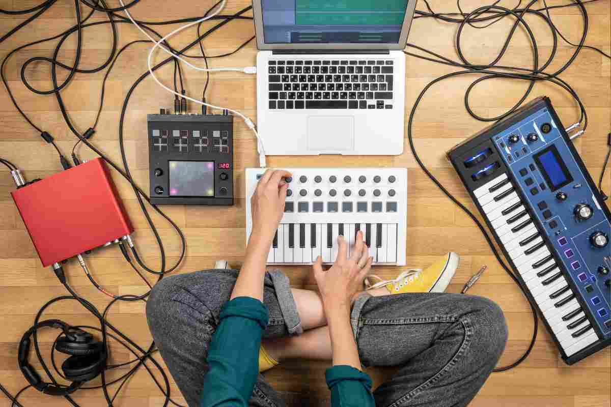 una ragazza con davanti strumenti per comporre musica elettronica