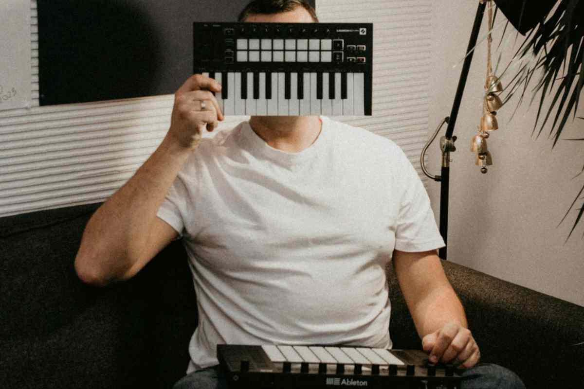 uomo con davanti alla faccia una tastiera midi